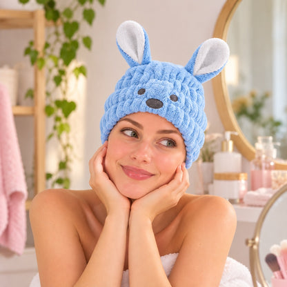 Femme portant un bonnet serviette pour cheveux kawaii bleu pastel, en forme de petit chien avec deux grandes oreilles, une bouille brodée et une texture douce et moelleuse. Ce bonnet absorbant maintient les cheveux humides sans qu'ils dépassent.