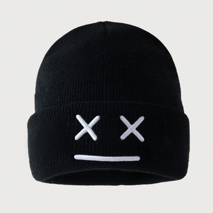 un bonnet à revers noir ou blanc brodé, représentant des yeux en forme de croix et une bouche minimaliste. Design tendance, moderne et minimaliste pour un look urbain street wear adorable.