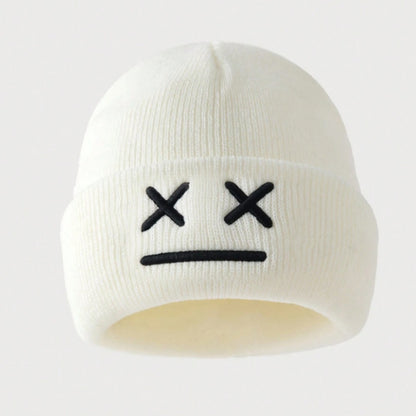 un bonnet à revers noir ou blanc brodé, représentant des yeux en forme de croix et une bouche minimaliste. Design tendance, moderne et minimaliste pour un look urbain street wear adorable.
