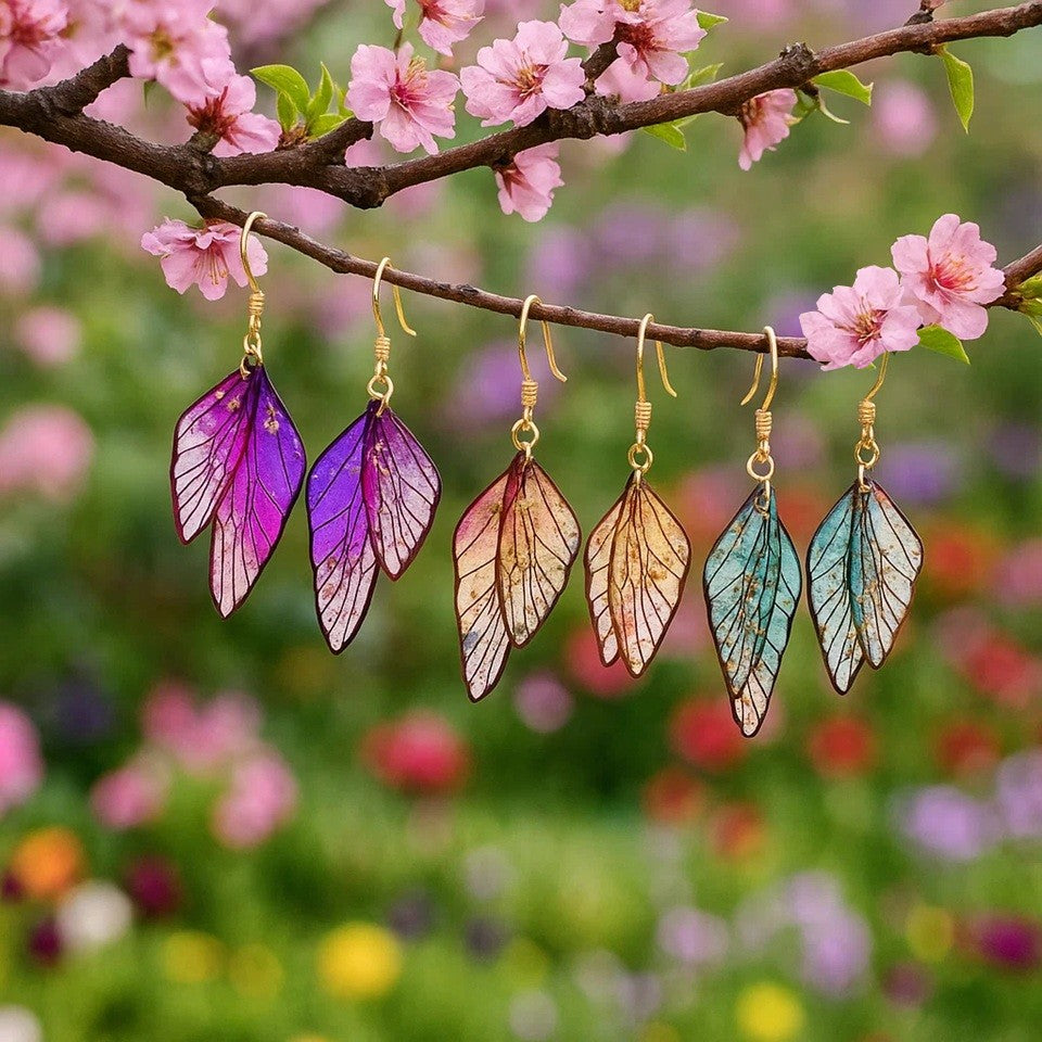 des boucles d'oreilles en forme d'ailes de fées colorées et toute pailletées. Elles semblent sortis d'un conte