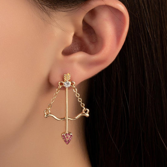 une paire de boucles d'oreilles en forme d'arc de cupidon avec sa flèche à la pointe strass roses