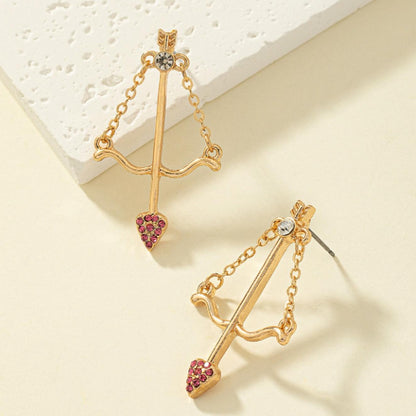 une paire de boucles d'oreilles en forme d'arc de cupidon avec sa flèche à la pointe strass roses