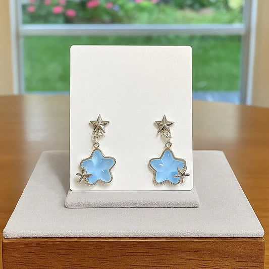 Une paire de boucles d'oreilles en forme d'étoiles bleues romantiques à souhait. 