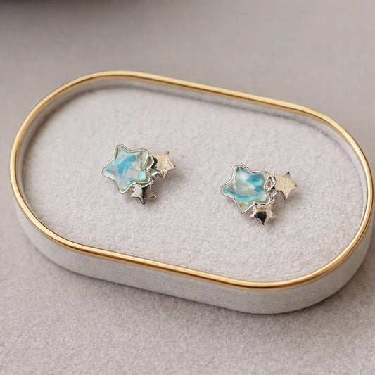 Une paire de boucles d'oreilles en forme d'étoiles bleues romantiques à souhait. 