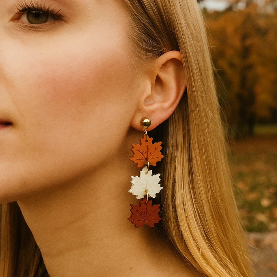 des boucles d'oreilles composées de trois feuilles d'érable orange, blanche et rouge. Elles rappellent l'automne et ses couleurs chatoyantes. En acrylique, elles sont légères et confortables à porter.