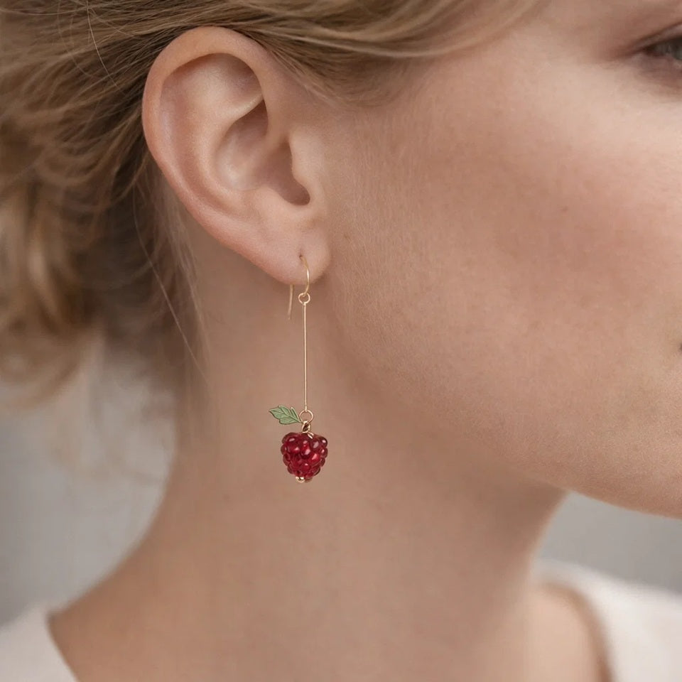 une paire de boucles d'oreilles en forme de framboise bien rouge et gourmande.
