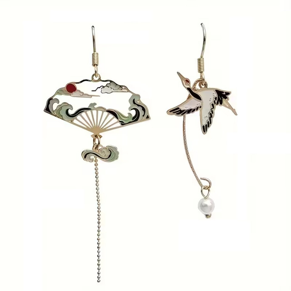 une paire de boucles d'oreilles dorés asymétriques. D'un côté, une grue japonaise et de l'autre, un éventail au motif de la grande vague de Kanagawa. Esthétique qui rappelle les estampes japonaises. Bijou élégant.