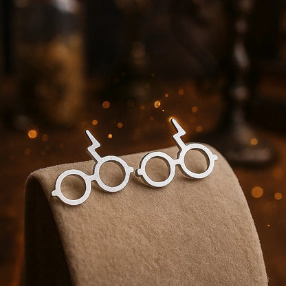 des boucles d'oreilles en forme des lunettes du sorcier le plus célèbre de Poudlard: Harry Potter. On retrouve également sa cicatrice.