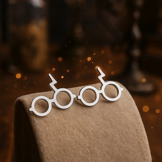 des boucles d'oreilles en forme des lunettes du sorcier le plus célèbre de Poudlard: Harry Potter. On retrouve également sa cicatrice.