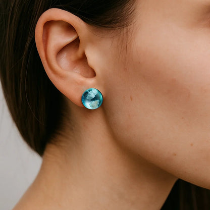 des boucles d'oreilles rondes en verre transparent et bleu. A l'intérieur, on peut voir comme des nuages blancs. On dirait que l'on a capturé un bout de ciel.