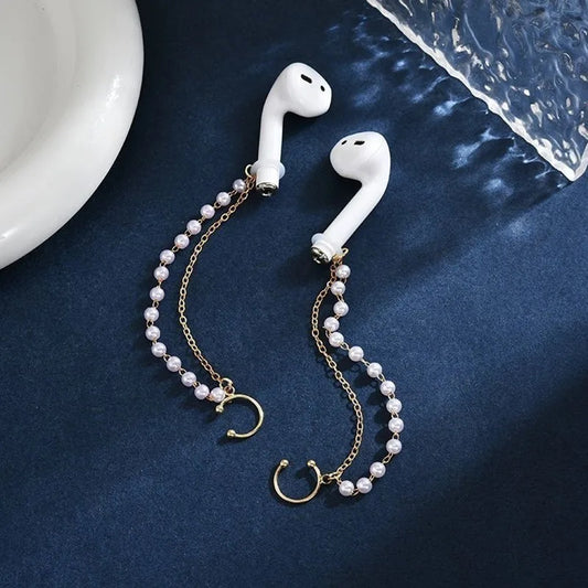 un bijou d'oreilles composée de deux chaines dorées et de perles blanches qui s'accrochent aux écouteurs sans fils. Style unique, original et mignon.