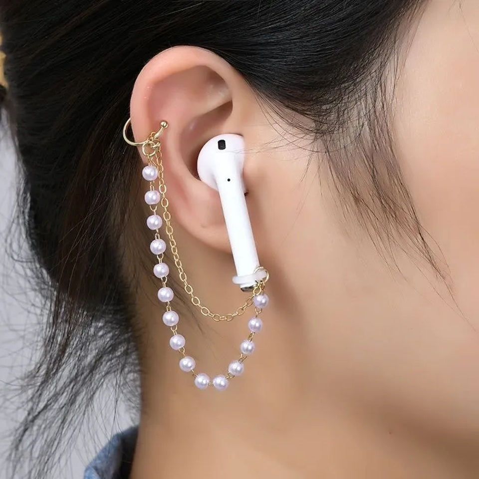 un bijou d'oreilles composée de deux chaines dorées et de perles blanches qui s'accrochent aux écouteurs sans fils. Style unique, original et mignon.