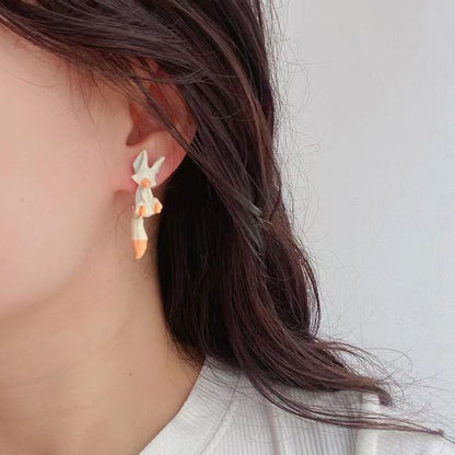 des boucles d'oreilles composées de deux renards : un blanc et un roux. Leur queue est pendante et le design est très mignon