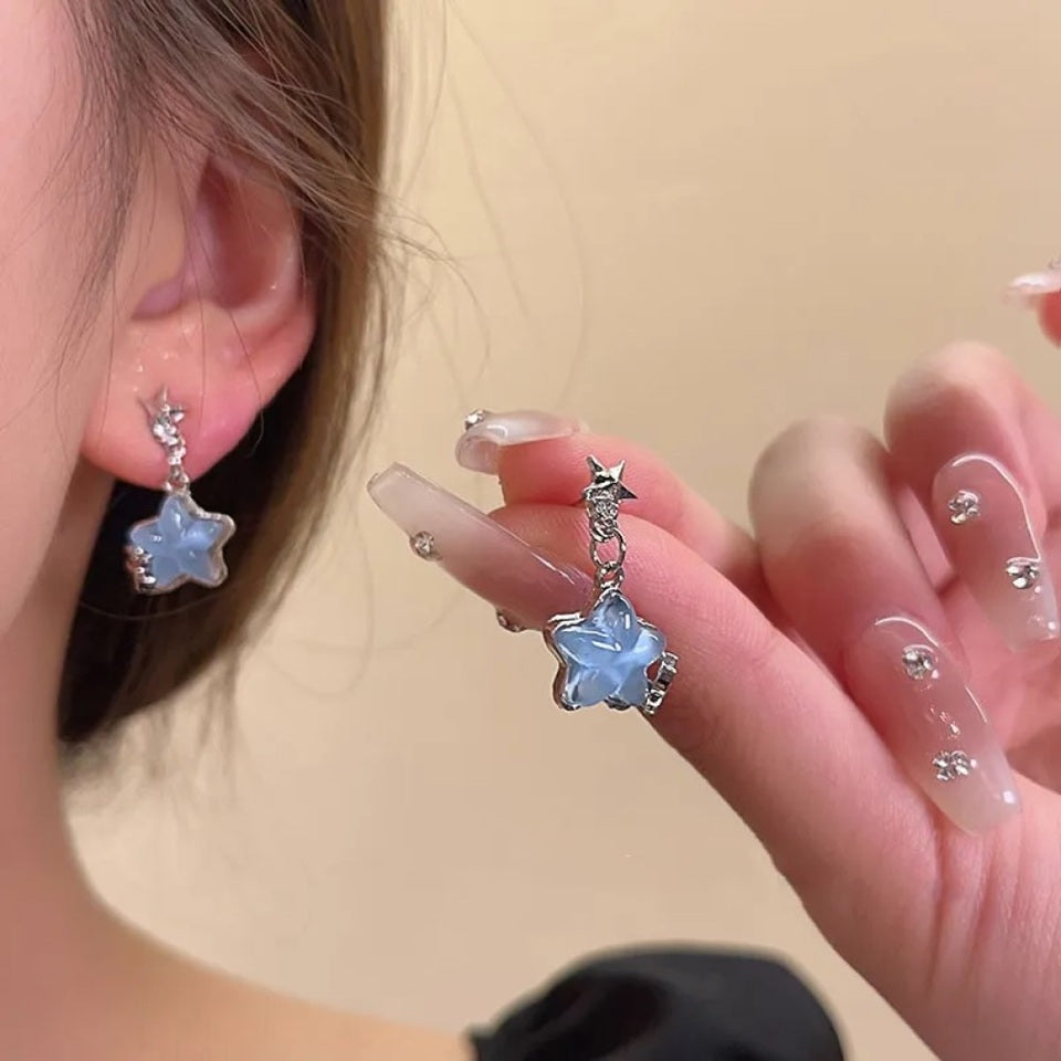 Une paire de boucles d'oreilles en forme d'étoiles bleues romantiques à souhait. 