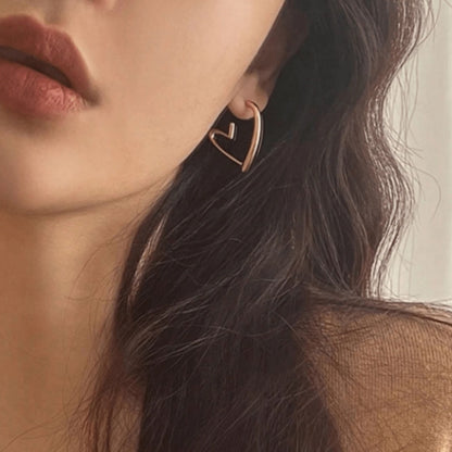 une paire de boucles d'oreilles en forme de coeurs dorés bien épais. Look intemporel, féminin, minimaliste
