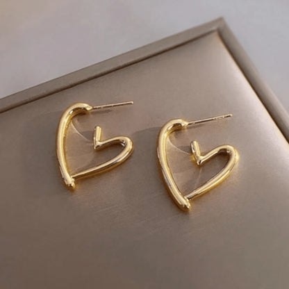 une paire de boucles d'oreilles en forme de coeurs dorés bien épais. Look intemporel, féminin, minimaliste