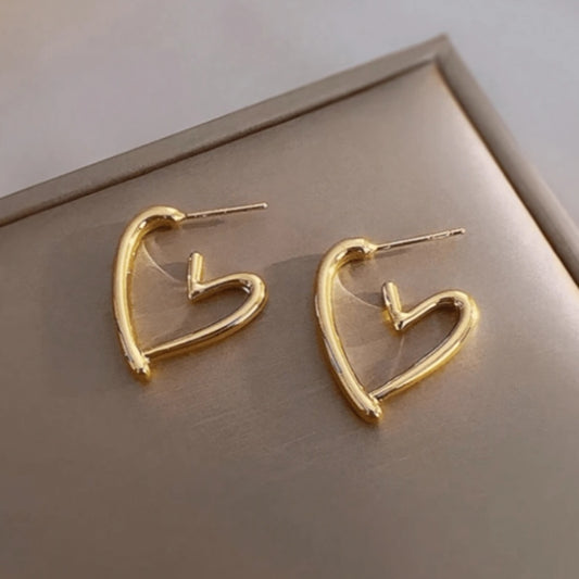 une paire de boucles d'oreilles en forme de coeurs dorés bien épais. Look intemporel, féminin, minimaliste