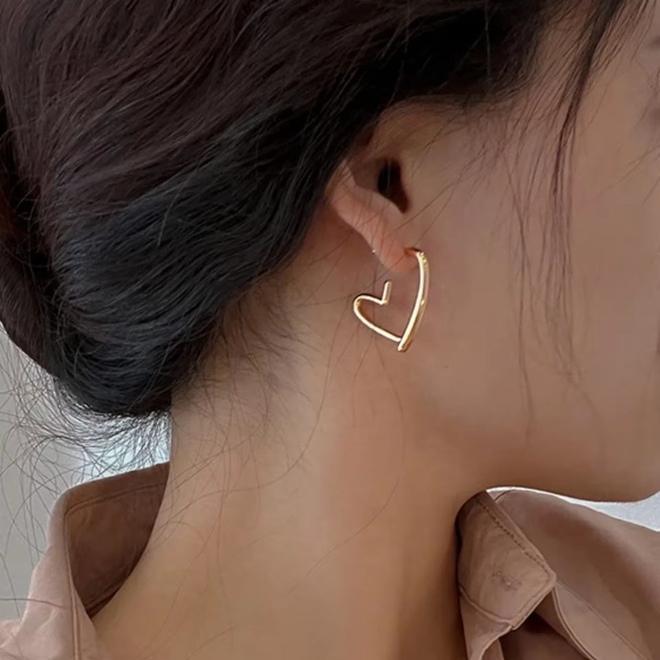 une paire de boucles d'oreilles en forme de coeurs dorés bien épais. Look intemporel, féminin, minimaliste