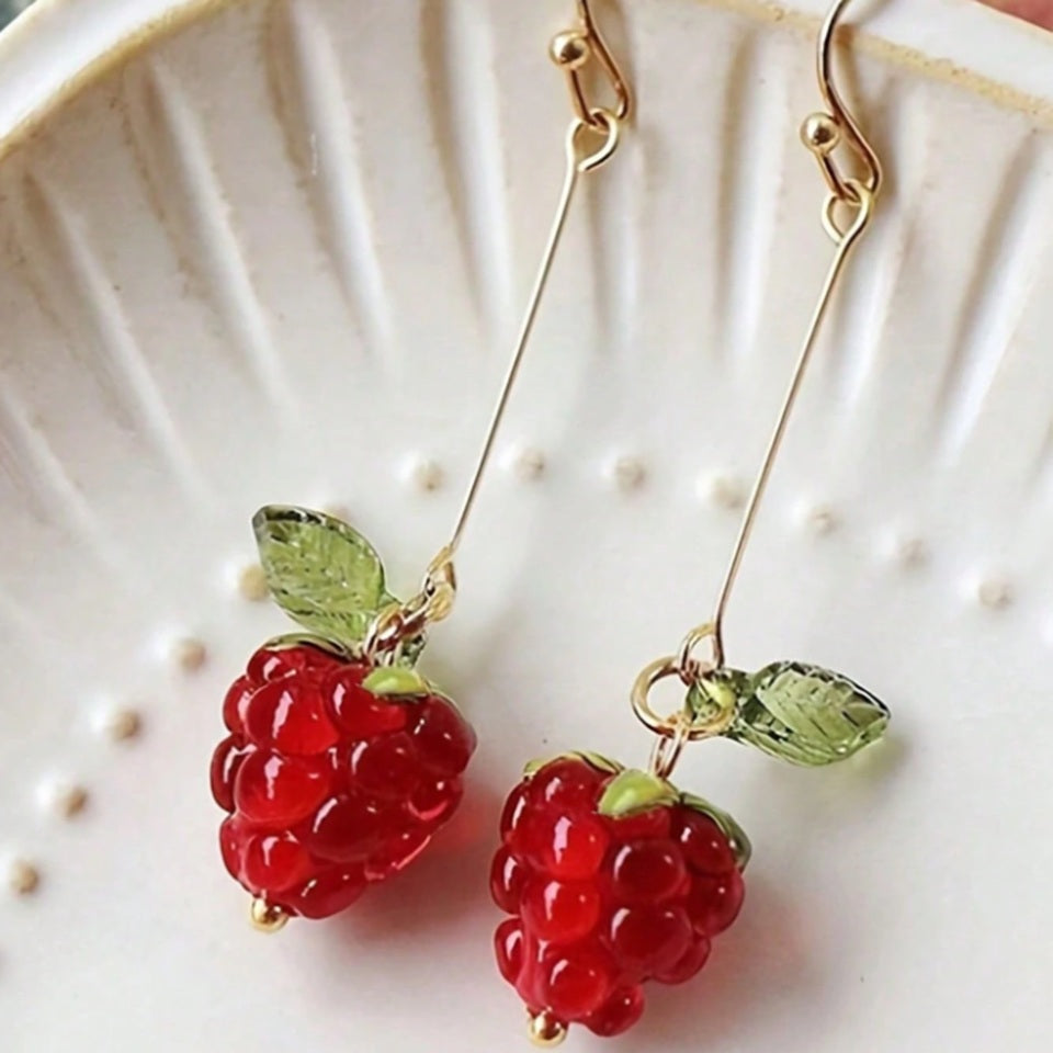 une paire de boucles d'oreilles en forme de framboise bien rouge et gourmande.