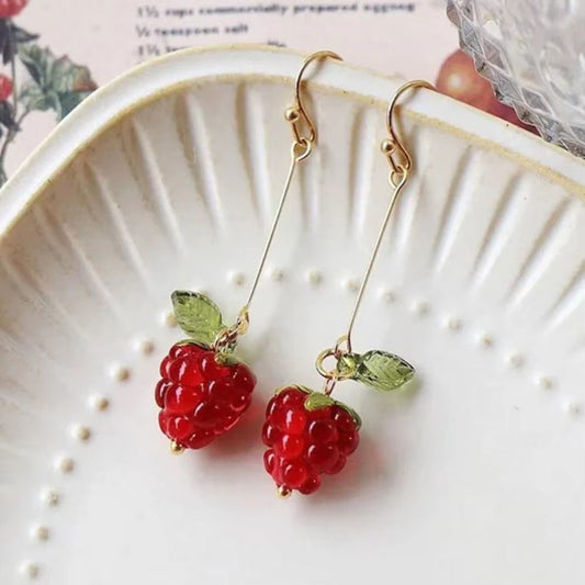 une paire de boucles d'oreilles en forme de framboise bien rouge et gourmande.