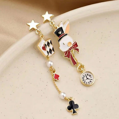 une paire de boucles d'oreilles asymétriques inspirés de l'univers d'Alice aux pays des merveilles. D'un côté un lapin blanc et sa montre, de l'autre, des cartes à jouer et des perles blanches.