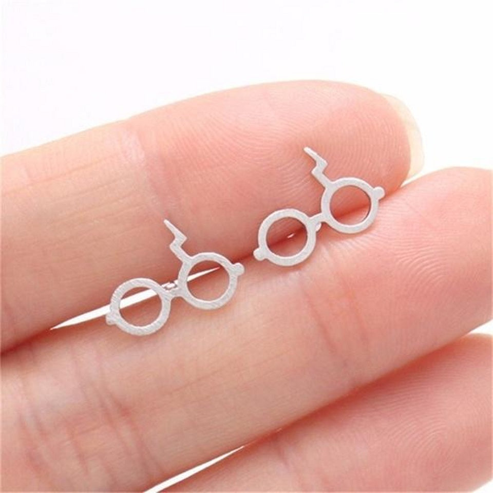 des boucles d'oreilles en forme des lunettes du sorcier le plus célèbre de Poudlard: Harry Potter. On retrouve également sa cicatrice.