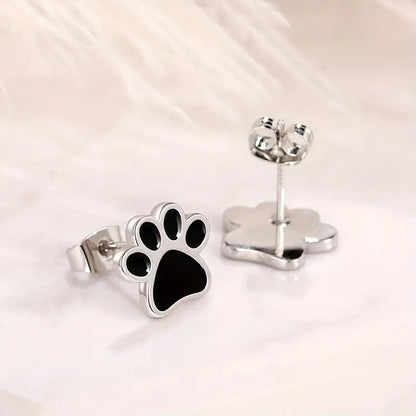 une paire de puces d'oreilles en forme de patte de chat noir.