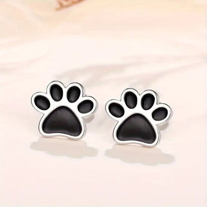 une paire de puces d'oreilles en forme de patte de chat noir.