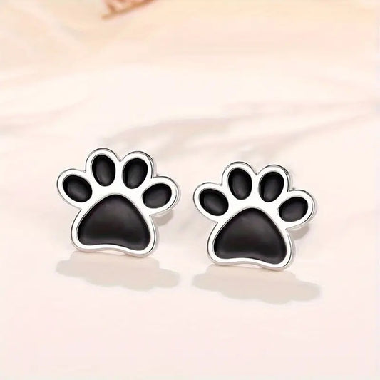 une paire de puces d'oreilles en forme de patte de chat noir.
