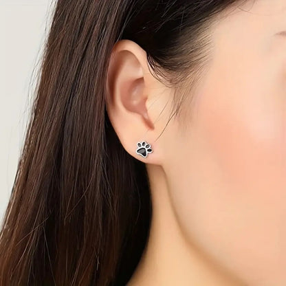 une paire de puces d'oreilles en forme de patte de chat noir.