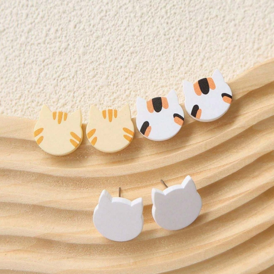 des boucles d'oreilles en forme de tête de chat de couleurs variées. Hyper mignonnes, minimalistes et adorables avec leur effet bois.