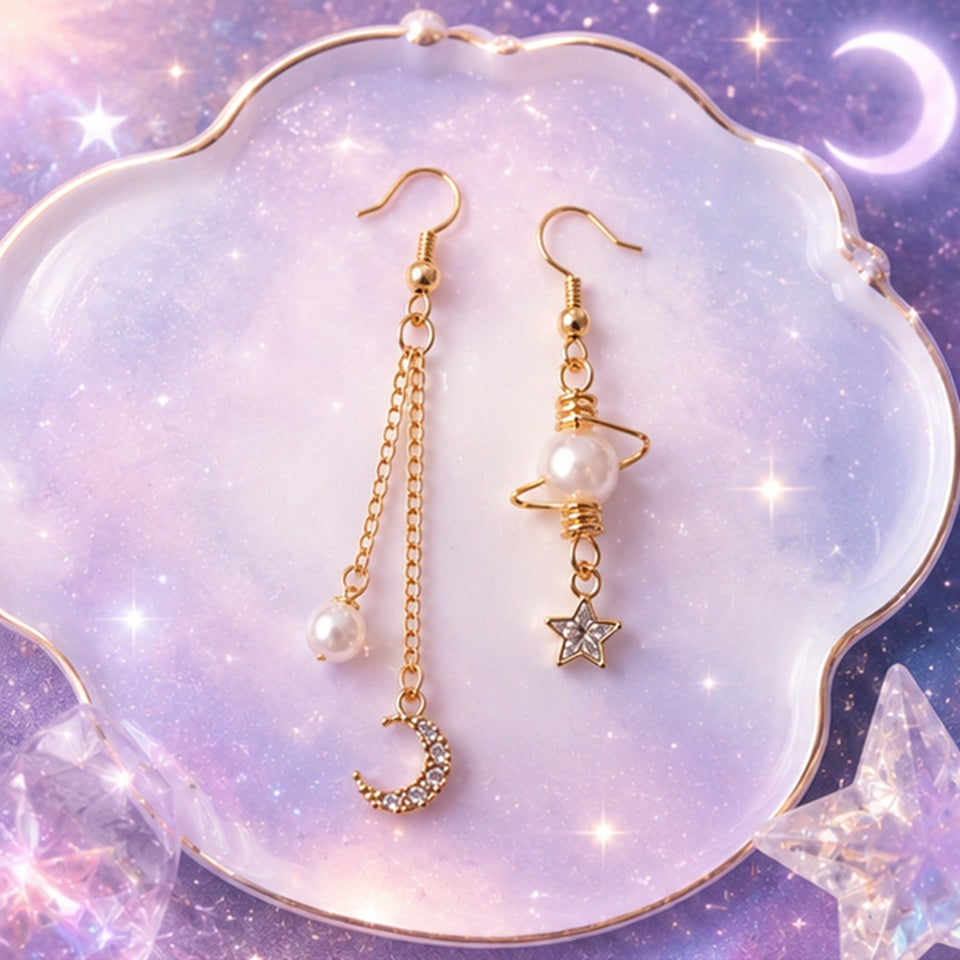 Boucles d’oreilles asymétriques dorées style kawaii céleste avec perles nacrées, lune strassée et étoile brillante. Design fin et élégant inspiré de l’univers spatial et féerique, parfait pour une tenue douce ou romantique.
