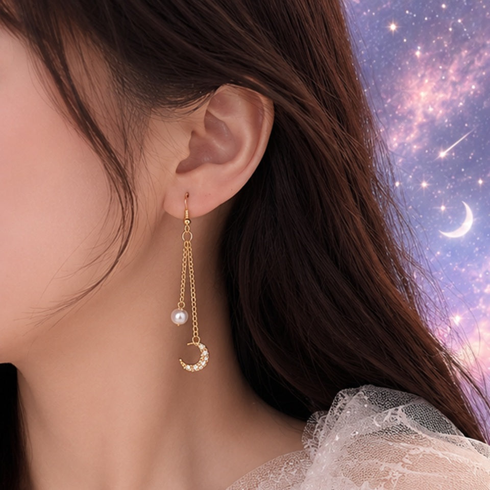 Boucles d’oreilles asymétriques dorées style kawaii céleste avec perles nacrées, lune strassée et étoile brillante. Design fin et élégant inspiré de l’univers spatial et féerique, parfait pour une tenue douce ou romantique.