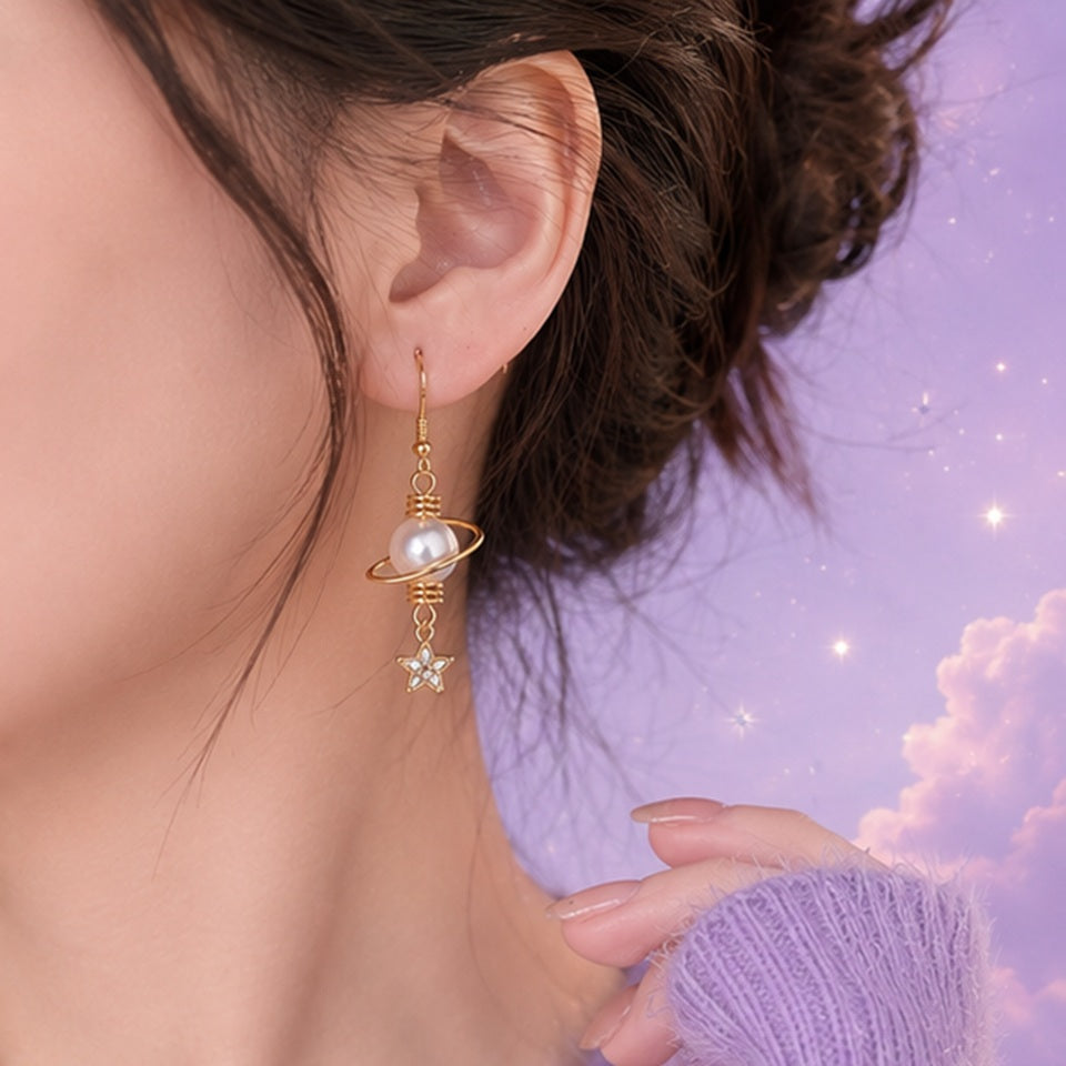 Boucles d’oreilles asymétriques dorées style kawaii céleste avec perles nacrées, lune strassée et étoile brillante. Design fin et élégant inspiré de l’univers spatial et féerique, parfait pour une tenue douce ou romantique.