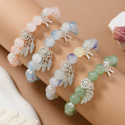 des bracelets composés de perles colorées et scintillantes avec une breloque attrape-rêves. Ensemble et look bohème chic
