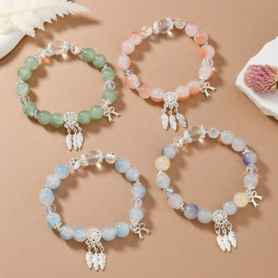 des bracelets composés de perles colorées et scintillantes avec une breloque attrape-rêves. Ensemble et look bohème chic