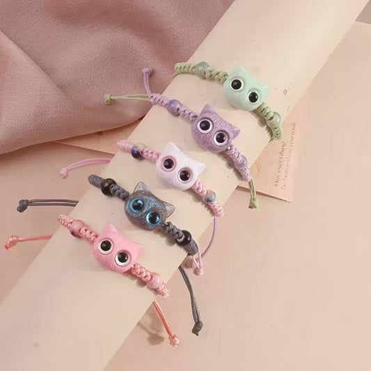 De jolis bracelets en corde tressée avec une breloque en forme de tête de chat colorée avec de gros yeux ronds brillants