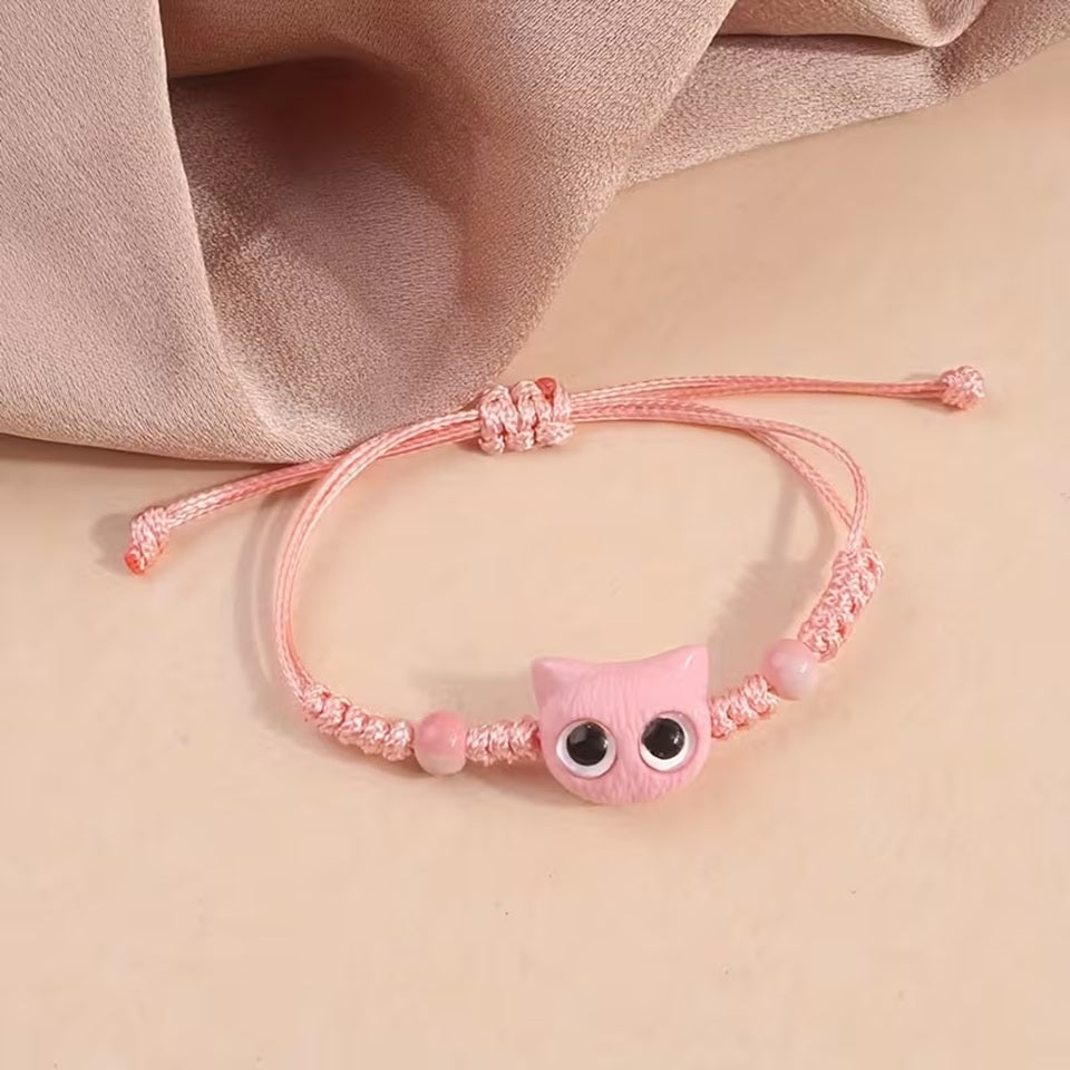 De jolis bracelets en corde tressée avec une breloque en forme de tête de chat colorée avec de gros yeux ronds brillants