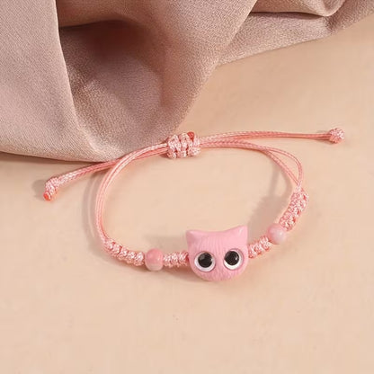 De jolis bracelets en corde tressée avec une breloque en forme de tête de chat colorée avec de gros yeux ronds brillants