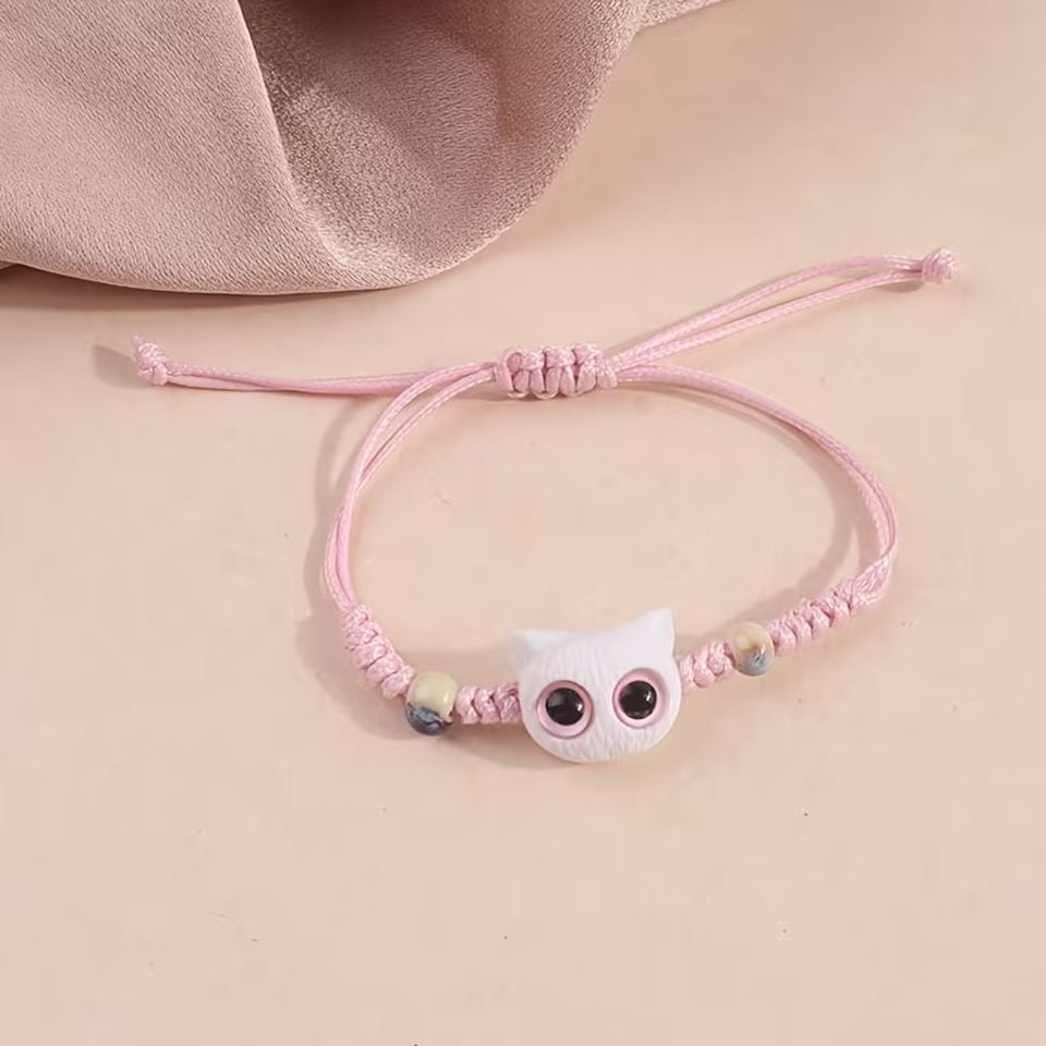 De jolis bracelets en corde tressée avec une breloque en forme de tête de chat colorée avec de gros yeux ronds brillants