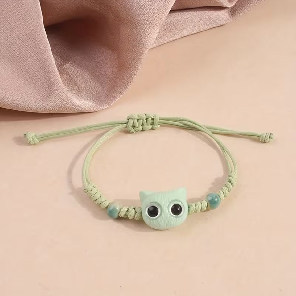 De jolis bracelets en corde tressée avec une breloque en forme de tête de chat colorée avec de gros yeux ronds brillants