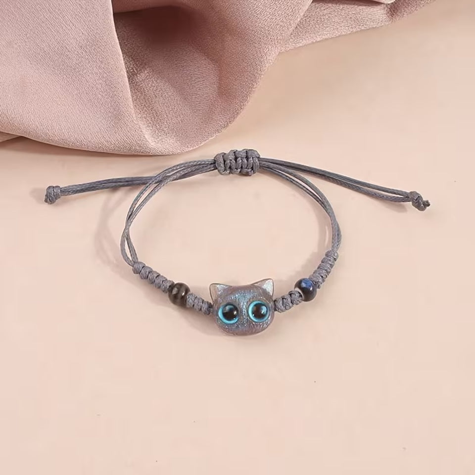De jolis bracelets en corde tressée avec une breloque en forme de tête de chat colorée avec de gros yeux ronds brillants