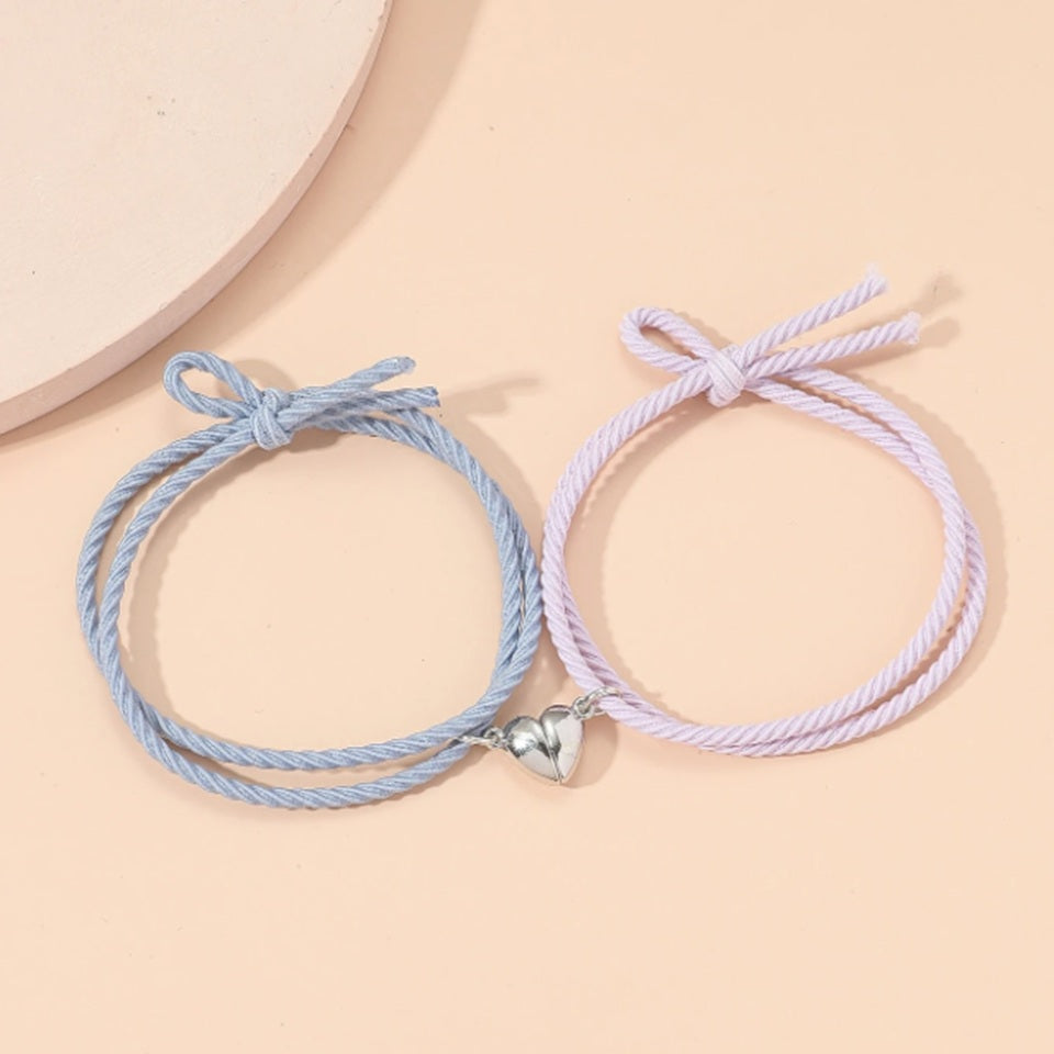 deux bracelets au cordon bleu et rose qui possède chacun une moitié de coeur aimanté. Quand ils sont réunis, le coeur se reforme.