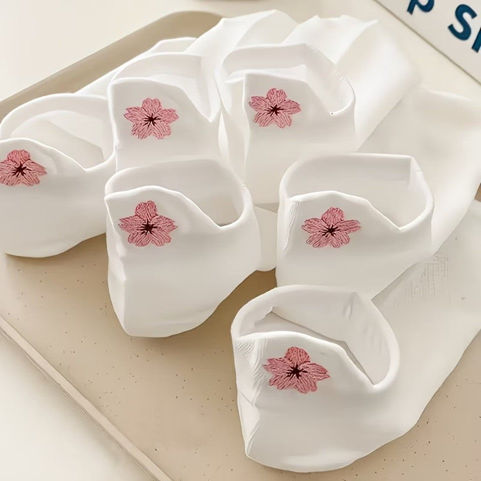 des chaussettes toutes douces blanches, une fleur de sakura rose est brodée à l'arrière