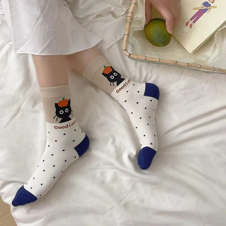 des chaussettes en coton toutes douces au motif d'un chat noir dans différentes situations adorables. Certains ont un motif de pois, d'autres de lignes.