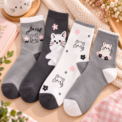 Chaussettes kawaii pour adulte grises et blanches décorées de petits chats et de fleurs, présentées dans un décor doux et chaleureux aux tons pastel.