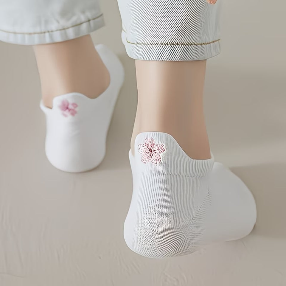 des chaussettes toutes douces blanches, une fleur de sakura rose est brodée à l'arrière