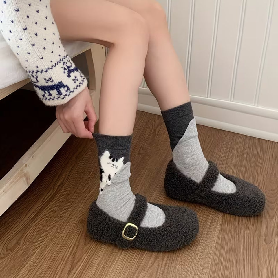 des chaussettes toutes douces représentant un chat posé sur une doublure cousue, comme s'il s'était endormi dessus. Cela crée un joli contraste adorable et original.