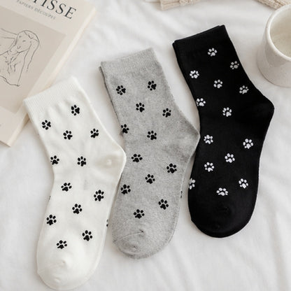 des chaussettes toutes douces noires, grises et blanches au motif d'empreintes de pattes de chat toutes mignonnes