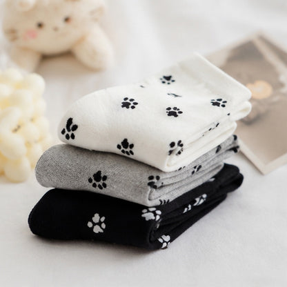 des chaussettes toutes douces noires, grises et blanches au motif d'empreintes de pattes de chat toutes mignonnes